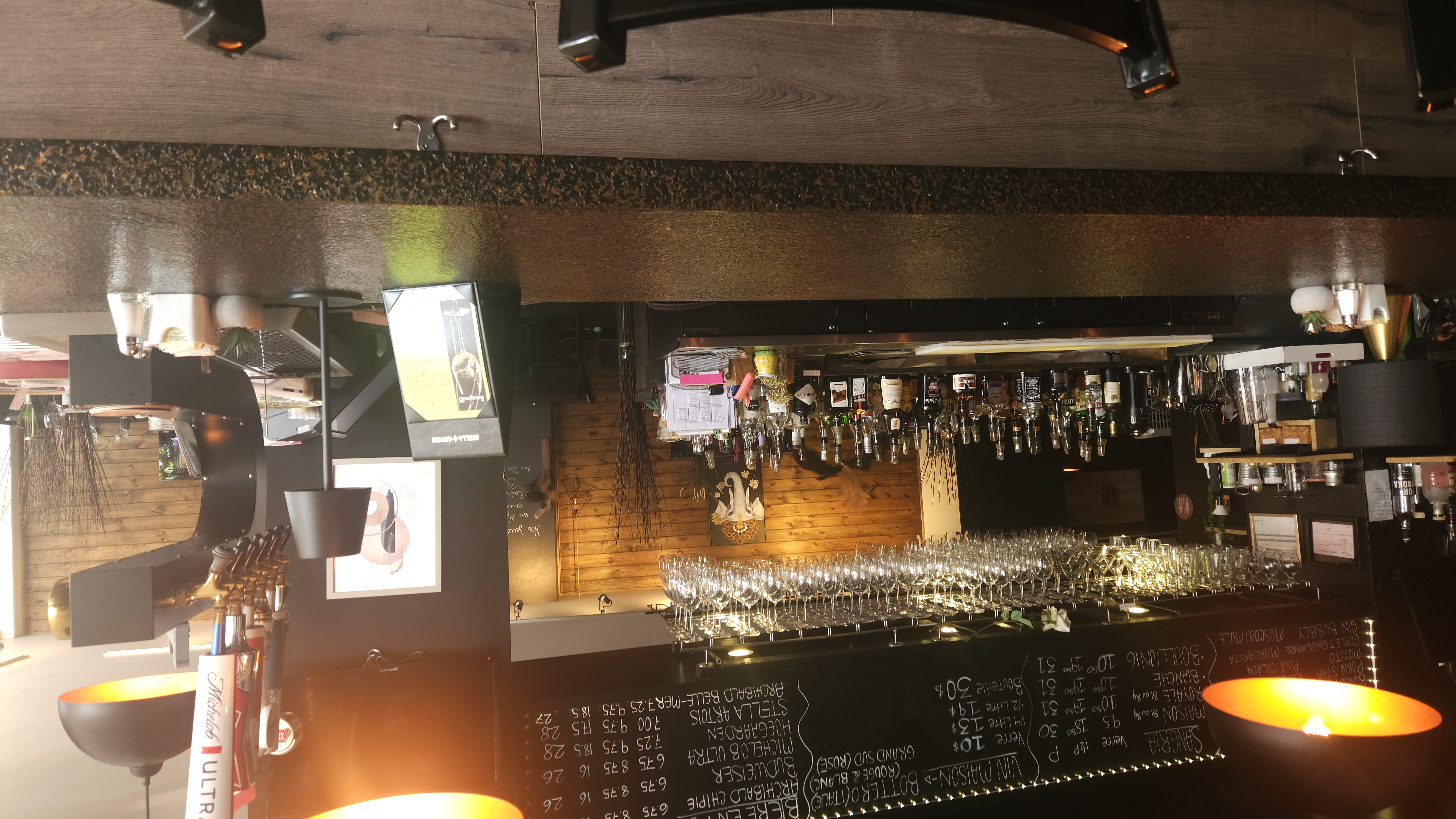 Bar central du restaurant LeBouillon16 avec éclairage chaleureux et verres